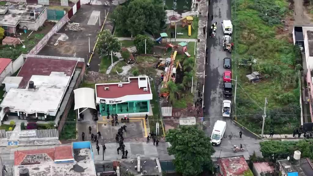 Agentes frente al edificio Bienestar del parque Pavigi de Xoxtla, con vehículos en la calle lateral