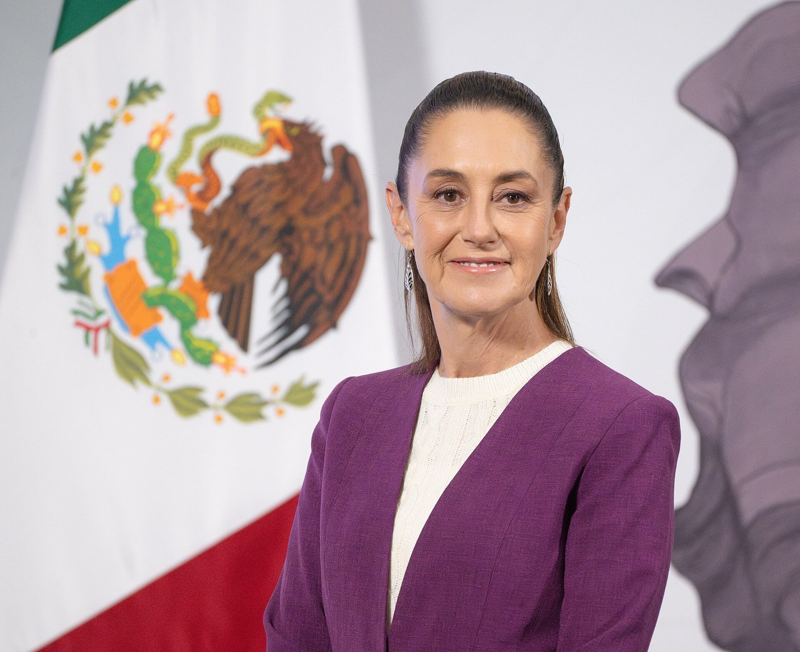 Retrato de la presidenta de México, Claudia Sheinbaum, frente a la bandera nacional